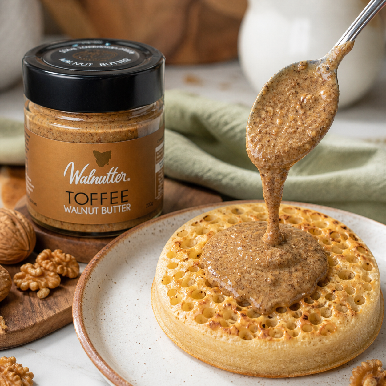 Walnutter toffee walnut butter being spooned over a toasted crumpet with visible toffee texture