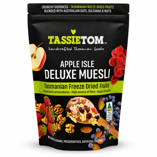 TassieTom Apple Isle Deluxe Muesli packaging with images of fruits and muesli on a black background.